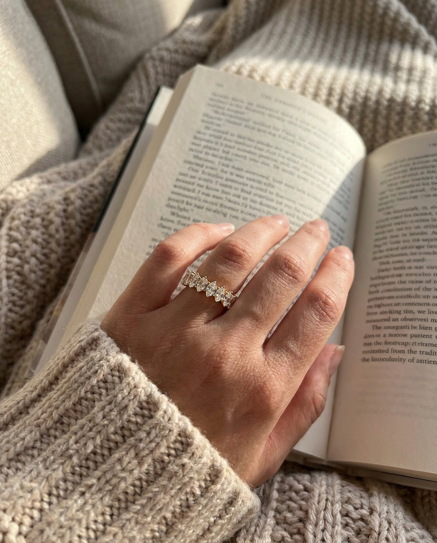 Elizabeth Eternity Ring on a hand resting on a book